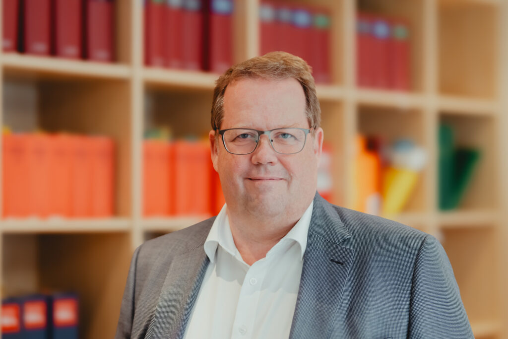 Axel Heidrich vor einem Bücherregal